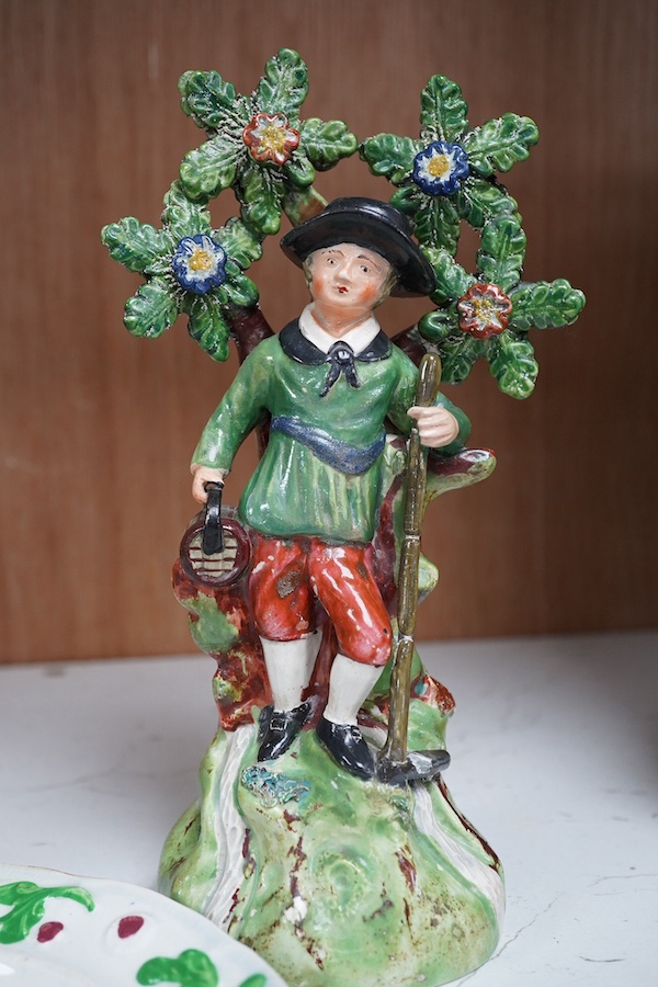 Two early 19th century Walton pearlware figures, the first a man holding a basket flowers, the second a cider costrel, tallest 19.5cm, together with a pearlware nursery plate (3). Condition – some restoration otherwise f